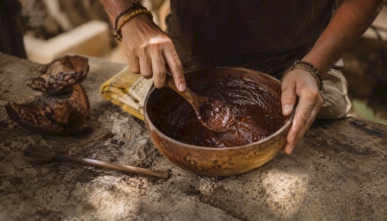 Hands stirring ceremonial cacao paste