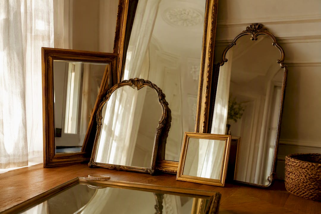 Room with many angled antique mirrors reflecting faces