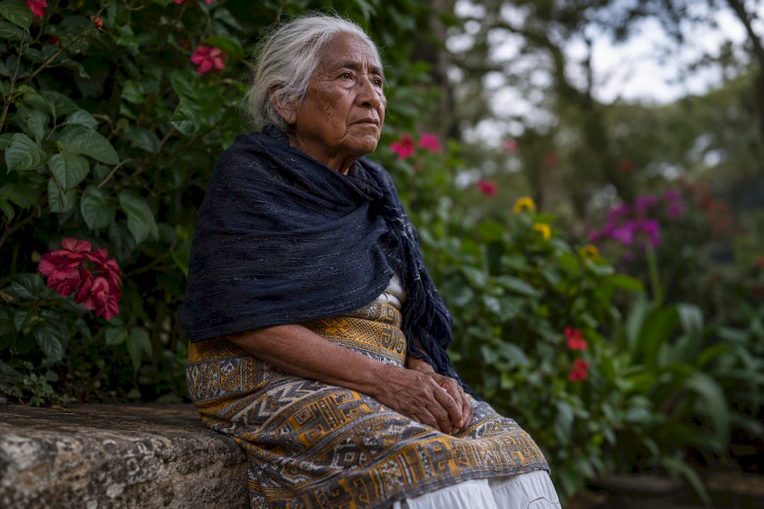 Elder person in garden with thoughtful expression